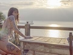 Молода дівчина скаче на члені на березі вечірнього океану